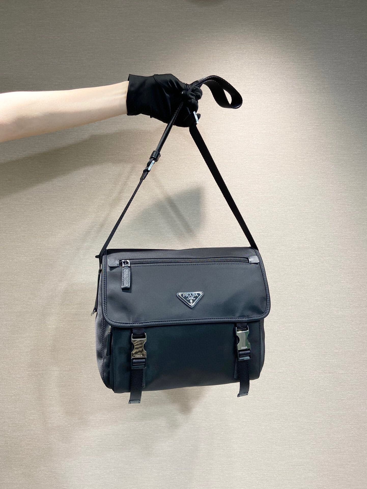 ??430?? New postman bag ??1BD953????
This messenger bag is embellished with Saffiano leather details. Decorated with logo and steel accessory triangle-shaped elements, with adjustable fabric shoulder straps, zipper, flap pocket opening and closing, large 