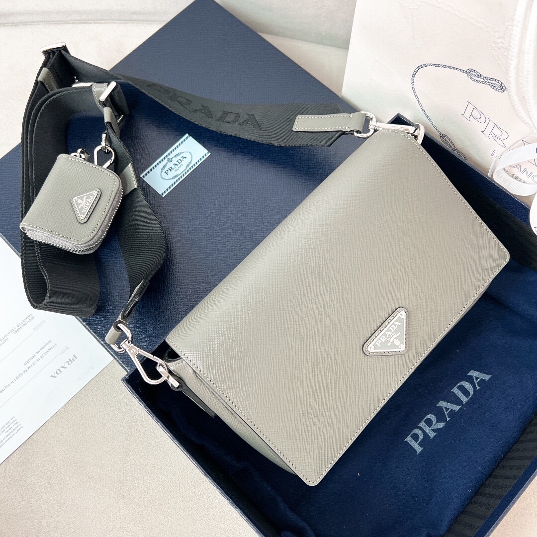 ??580?? New grey ??2VD059????
This single-shoulder bag is made of Saffiano leather. The one-shoulder flap magnetic clasp design, detachable adjustable nylon shoulder strap, detachable Saffiano leather pocket, simple and elegant, very stylish when worn. An