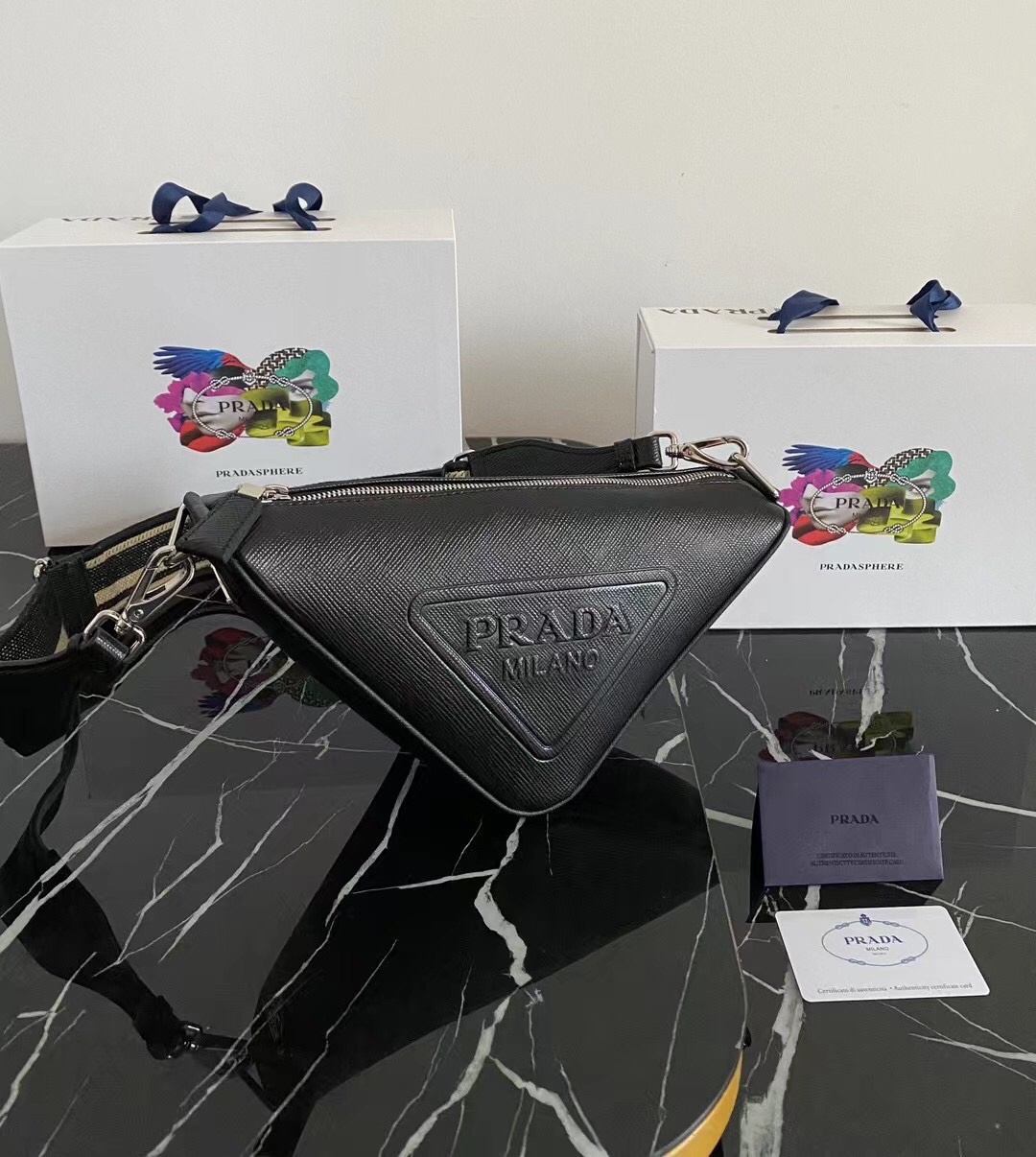 p650?? Embroidered webbed Triangle bag ??2VH155???? This triangle bag takes the brand 's signature geometric shape and is made of the brand' s signature Saffiano leather, featuring a distinctive cross and parallel pattern, large embossed triangular logo, 